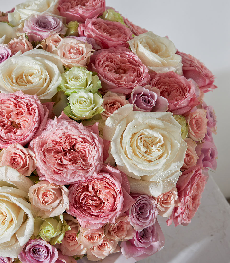 Luxury pastel rose bouquet with blush pink, cream, and lavender blooms in lush domed arrangement