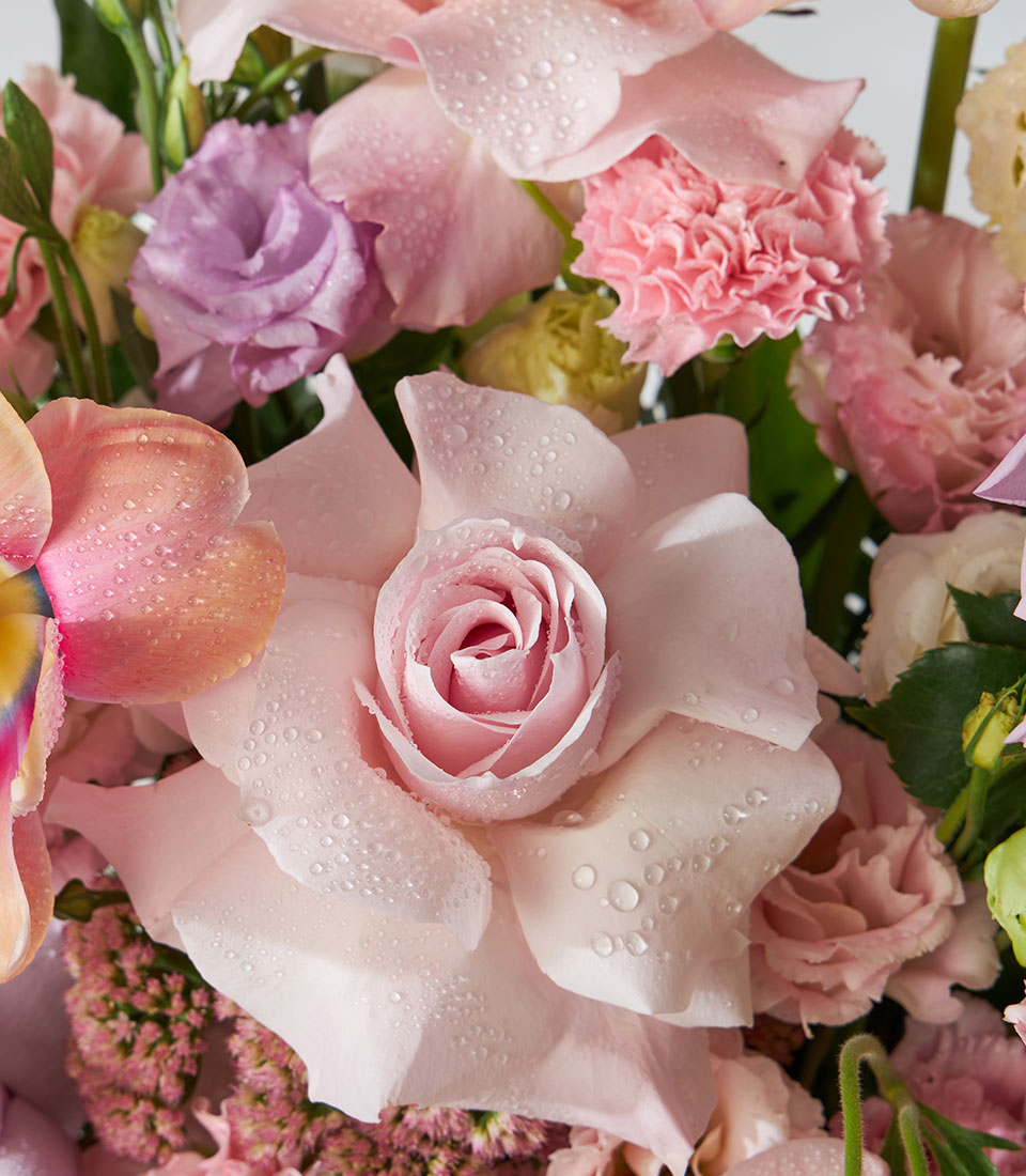 Pastel pink and purple fresh flower basket with roses, lisianthus, and carnations