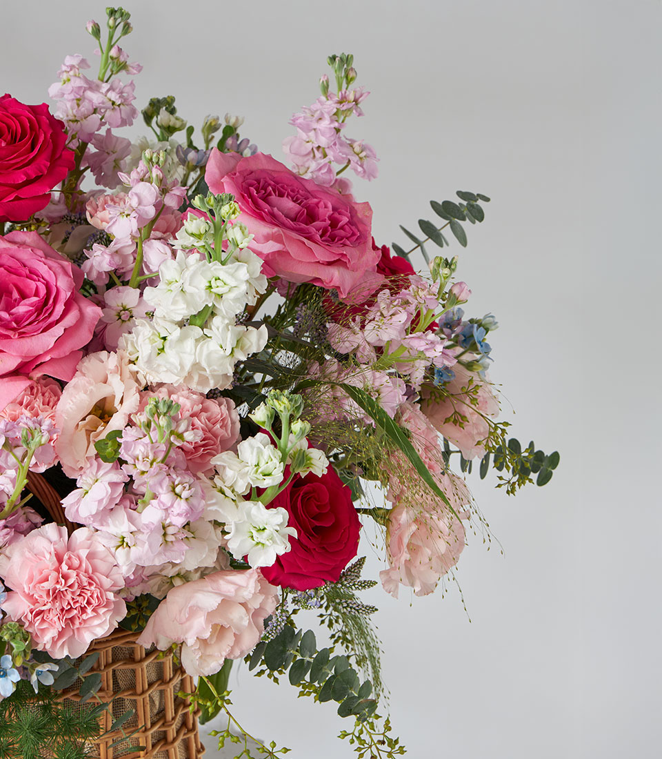 Nuage & Full Monty roses garden basket with pink, white, and red blooms in woven basket