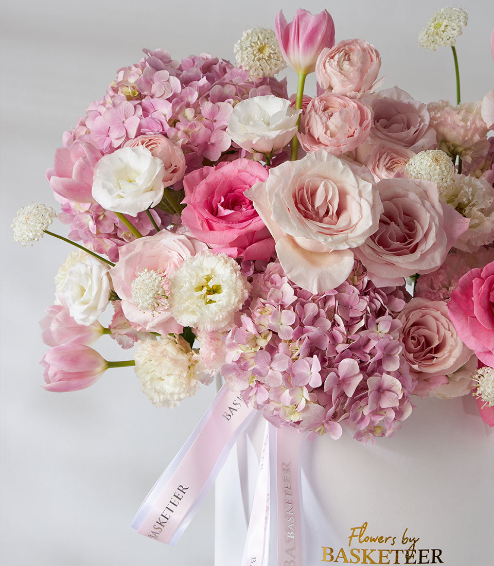 Luxury pink and white rose, ranunculus, and tulip arrangement in pearl leather flower box