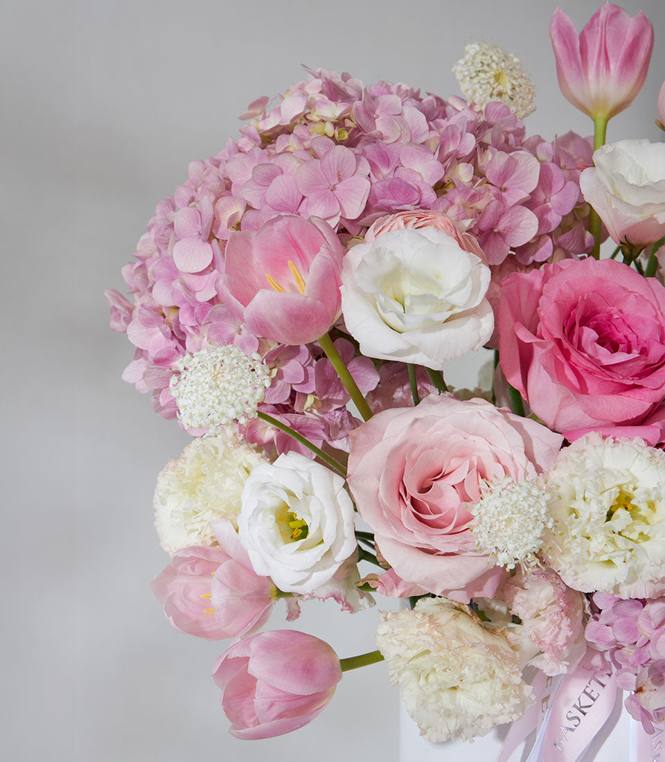 Pink and white roses, hydrangeas, tulips, and ranunculus in pearl leather flower box