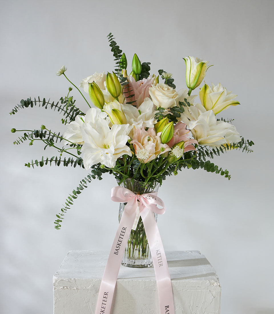 White roses and pink lilies with eucalyptus in crystal vase, premium fresh flower arrangement