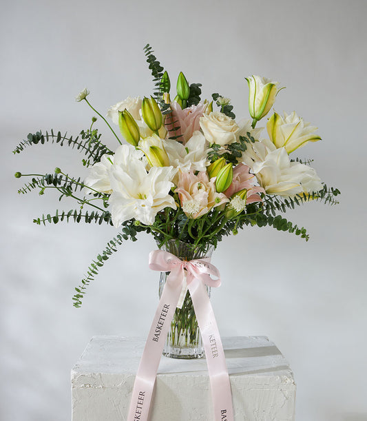 White roses and pink lilies with eucalyptus in crystal vase, premium fresh flower arrangement