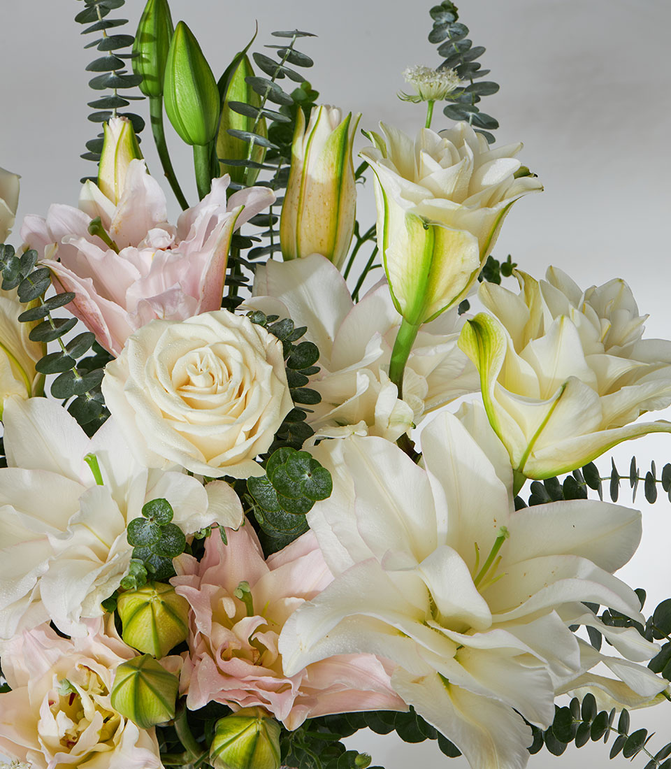 White roses and lilies with pink eustoma in crystal glass vase, premium fresh flower arrangement