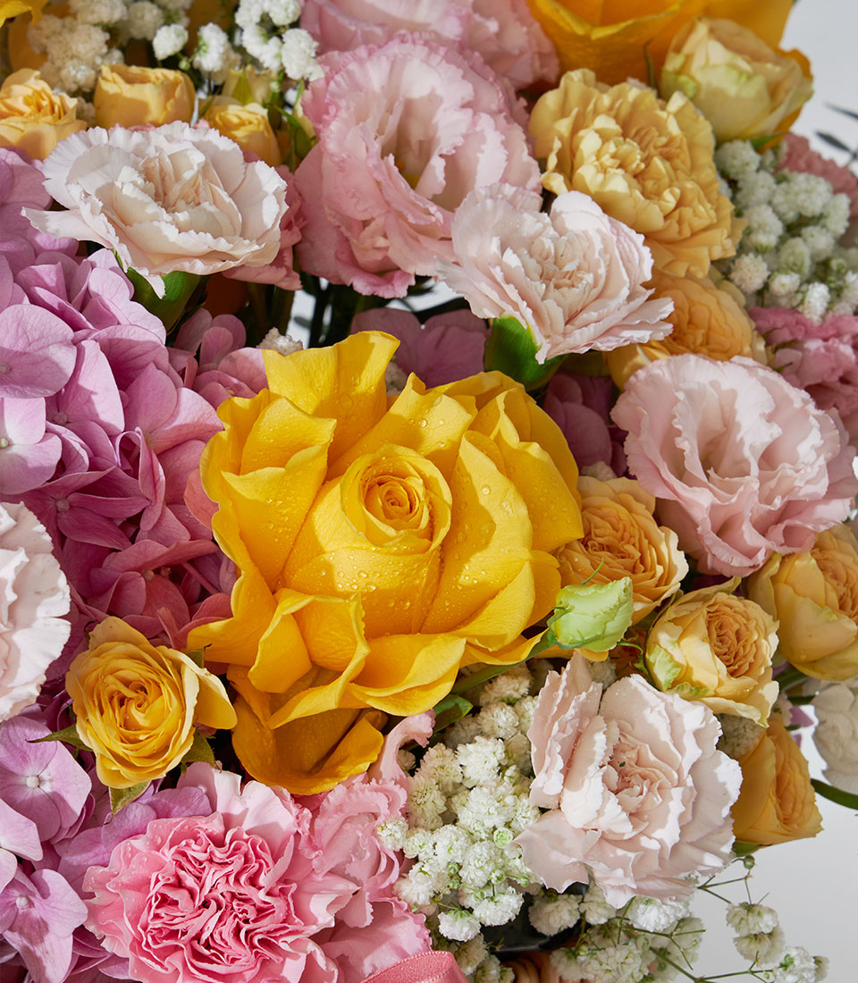 Premium pink and yellow rose arrangement with hydrangeas and lisianthus in a luxury gift basket