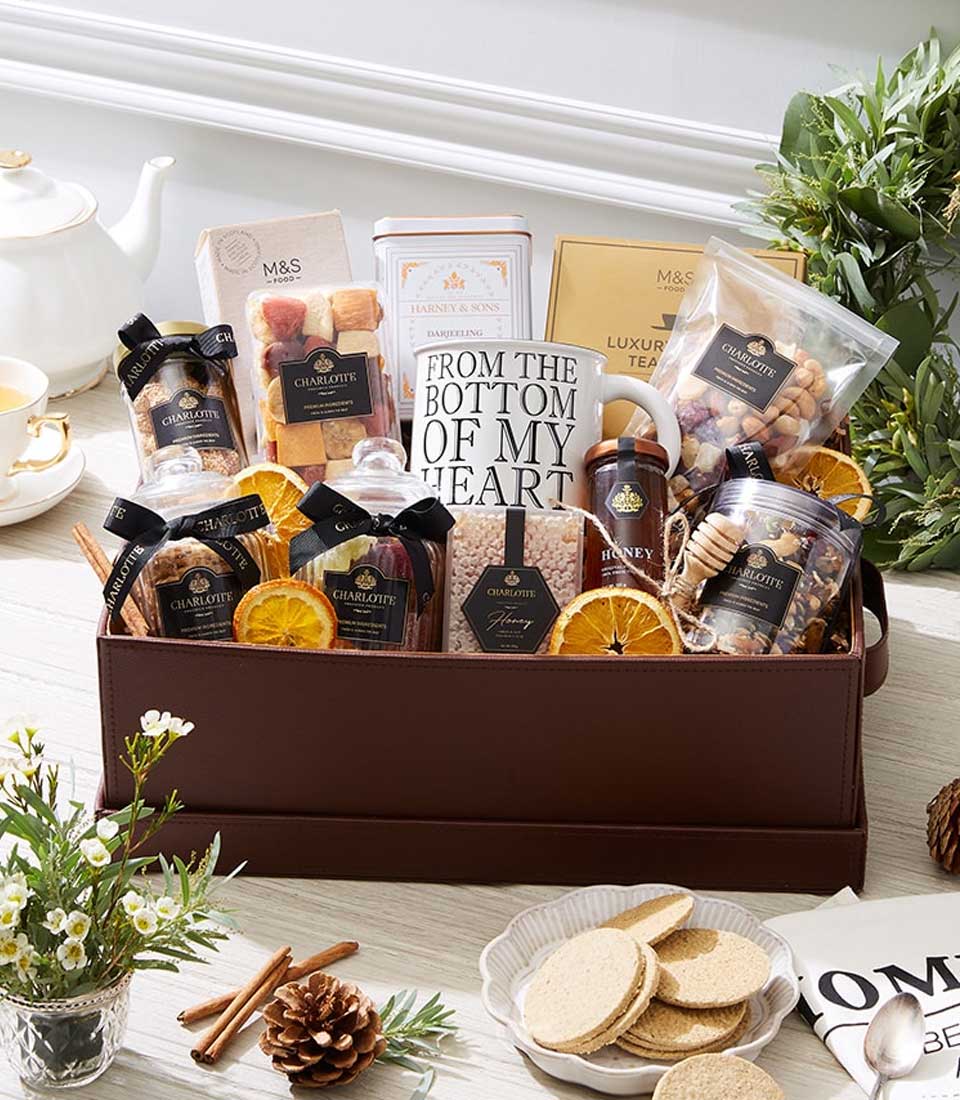 Premium wellness gift hamper with dried fruits, nuts, gourmet tea, and honey in dark leather box