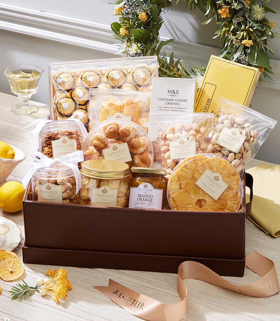 Luxury gourmet gift basket with Ferrero Rocher chocolates, Charlotte pastries, nuts, dried fruits, and artisan preserves in