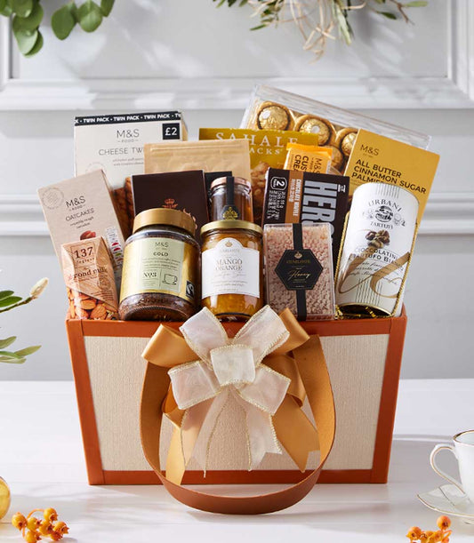 Luxury gift hamper with gourmet chocolates, coffee, preserves, and artisan biscuits in beige box with gold ribbon