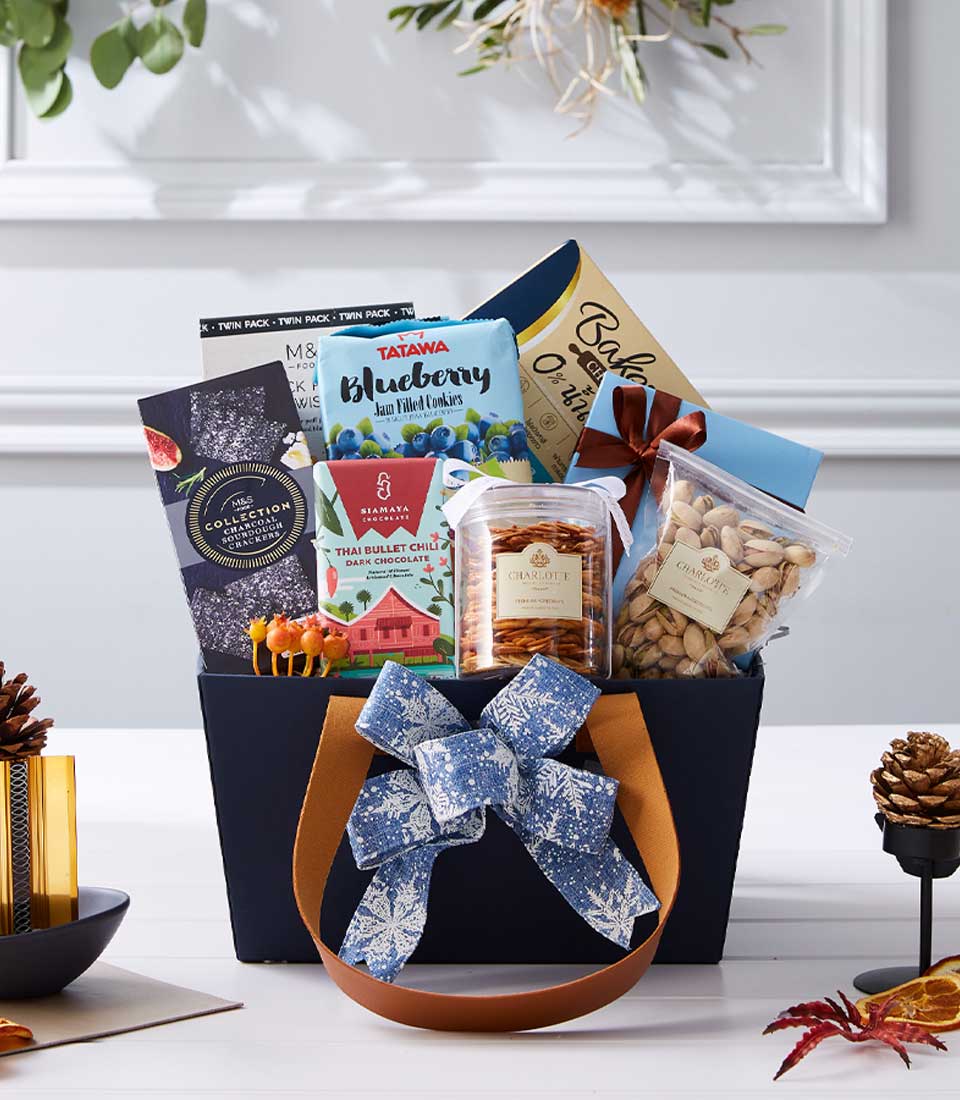 Dark blue premium gift basket with gourmet treats, blueberry cookies, dark chocolate, and crackers for New Year gifting