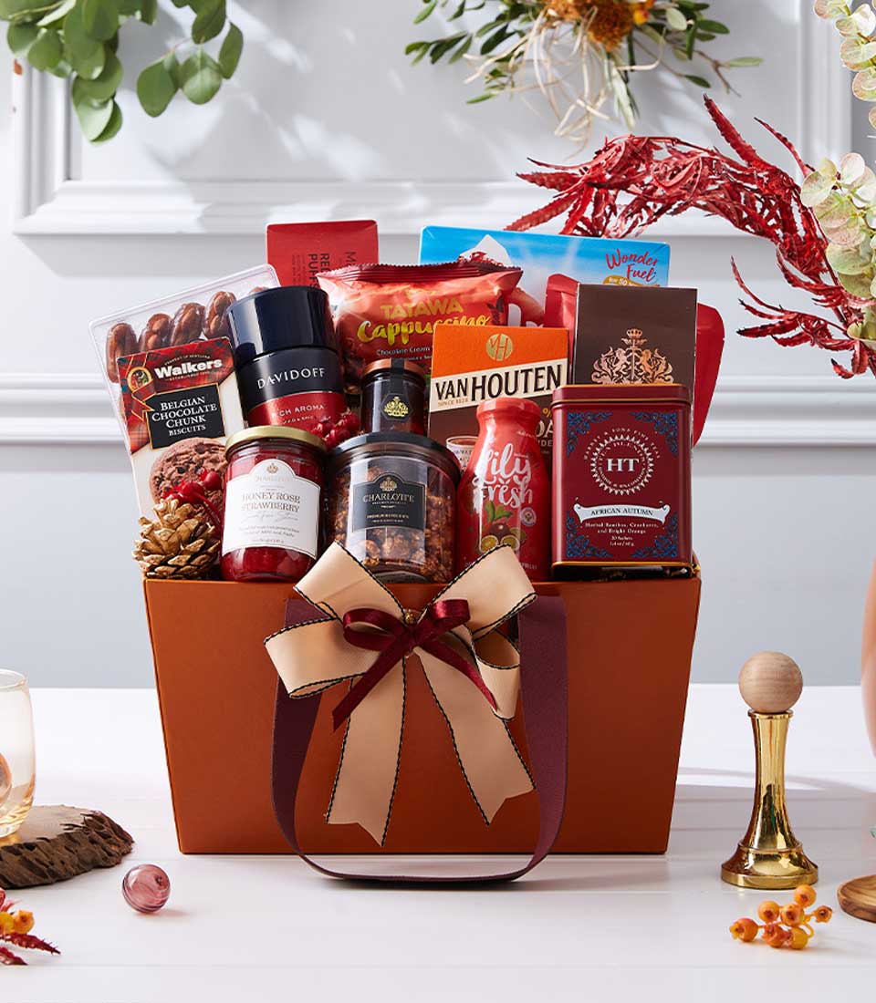 Rust-orange luxury gift basket filled with gourmet chocolates, coffee, cappuccino, jam, granola, and tea for New Year
