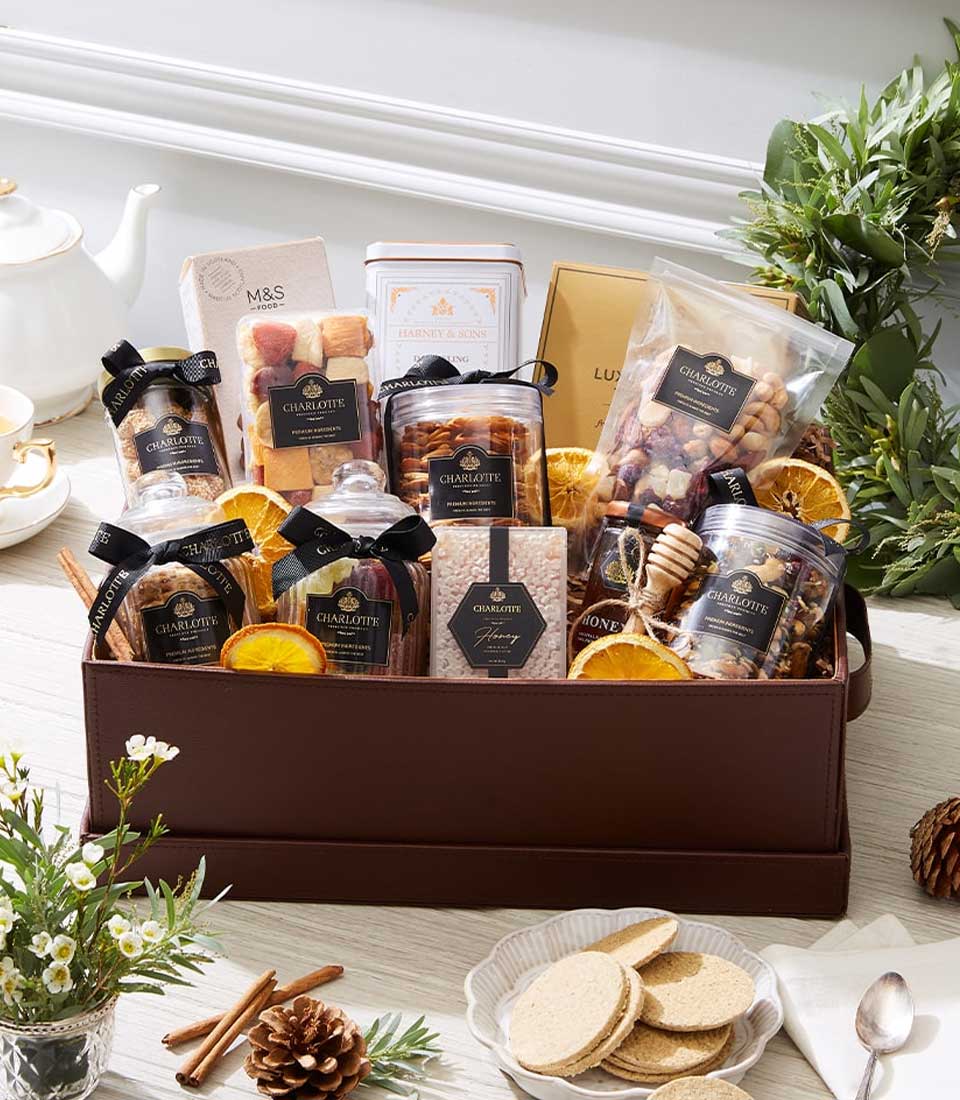 Premium gourmet gift hamper with nuts, dried fruits, honey tea, and artisan treats in brown leather box