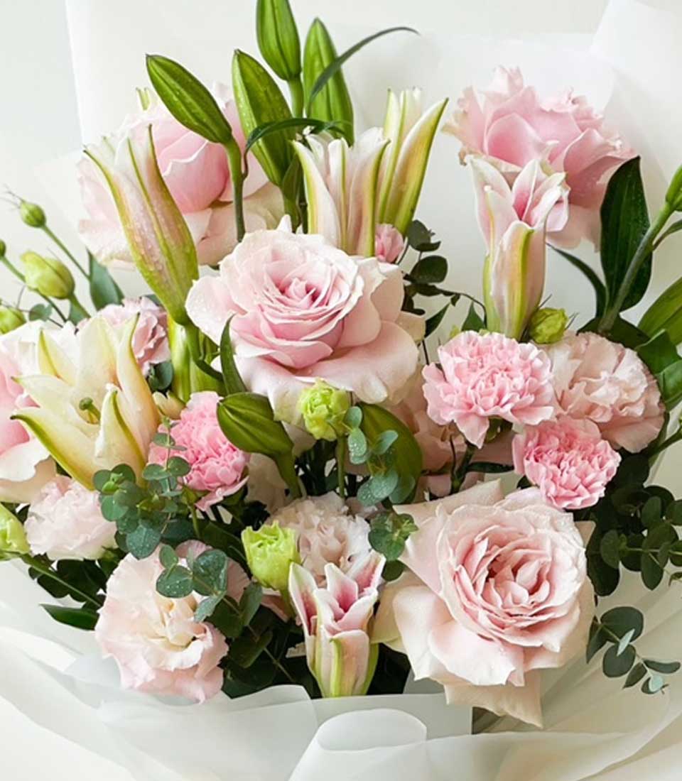 Fresh pink roses and white lilies bouquet wrapped in white paper, premium flower gift arrangement