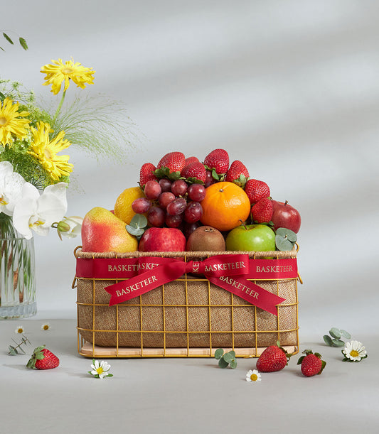 Luxury mixed fruit basket with strawberries, kiwi, apples, and citrus in gold wire frame with burlap lining
