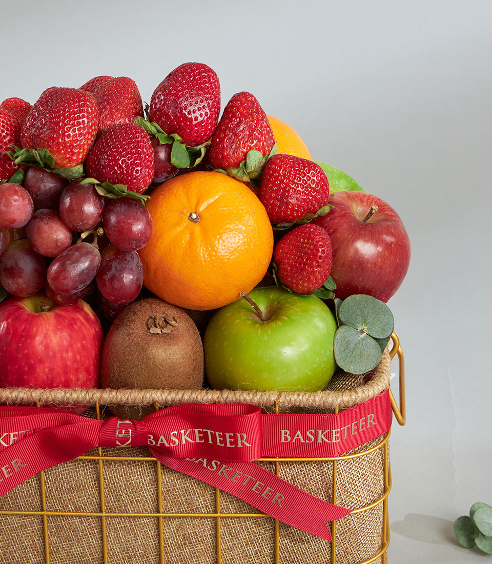 Premium mixed fruit gift basket with strawberries, kiwi, and fresh citrus in golden wire design