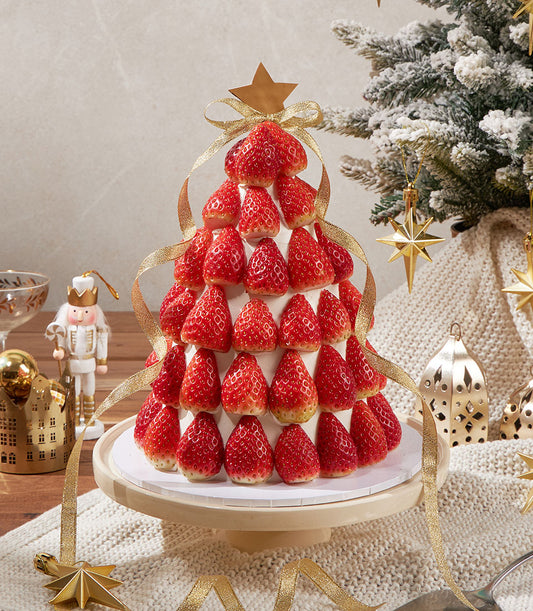 Charlotte Bakery Christmas tree artisan cake, a British-style sponge with cream cheese frosting, decorated with fresh strawberries and gold ribbon. Order custom cake Bangkok.