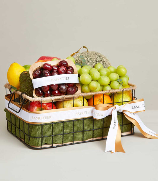 Orchard Fresh Fruits Basket with green grapes, cherries, cantaloupe, apples, pears and citrus in black wire basket with