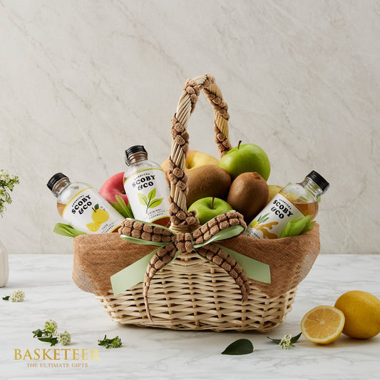 Premium mixed fruit and wellness drink gift basket with fresh apples, kiwis, and artisan beverages in woven wicker