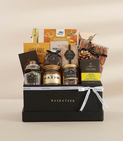 Luxury gourmet gift basket with sparkling wine, artisan biscuits, honey, and coffee in black leather box with gold ribbon