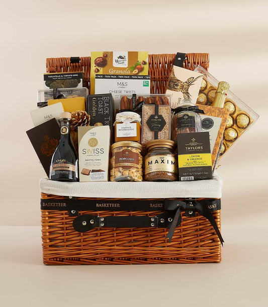 Luxury gourmet gift hamper with wicker basket, artisan chocolates, truffle pasta, marmalade, and sparkling wine