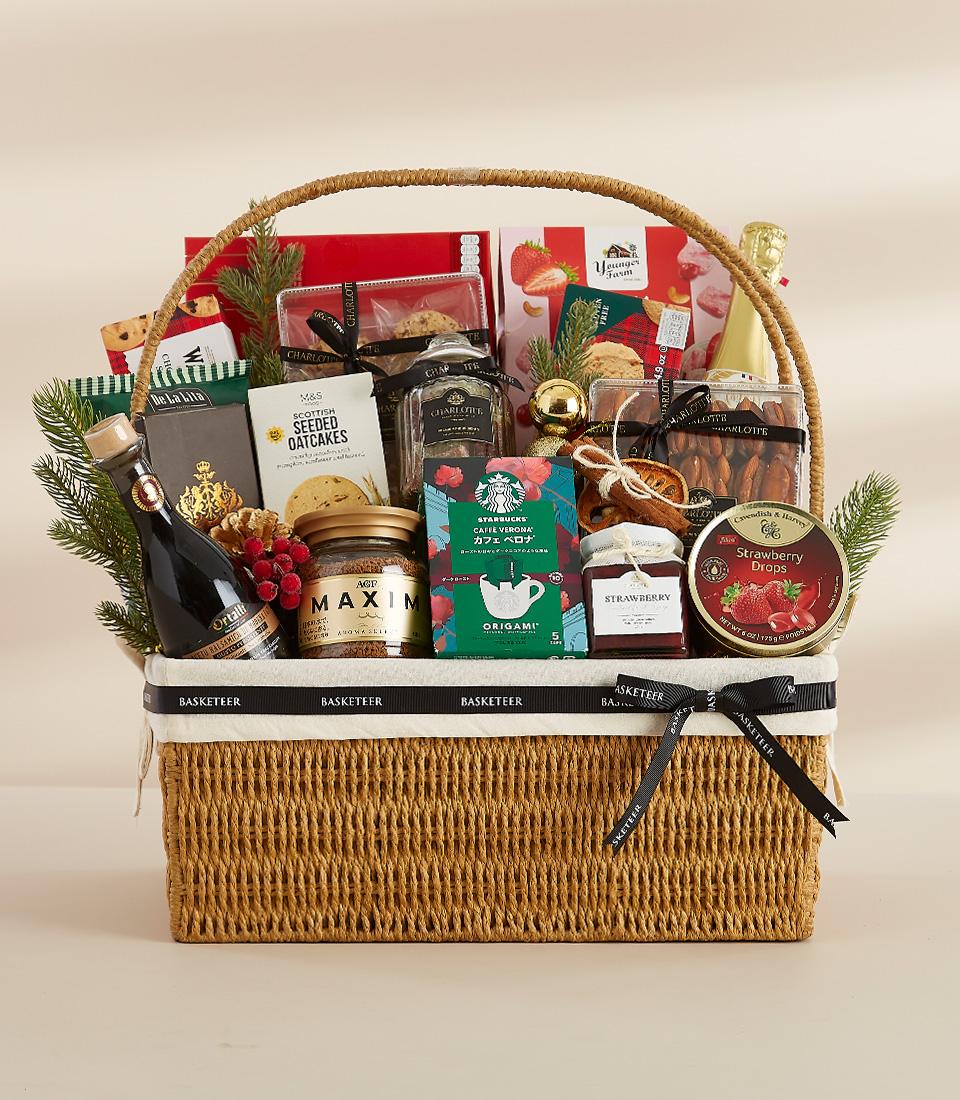 Winter Wonderland luxury gourmet basket with coffee, oatcakes, jam, and festive greenery in woven light brown with black
