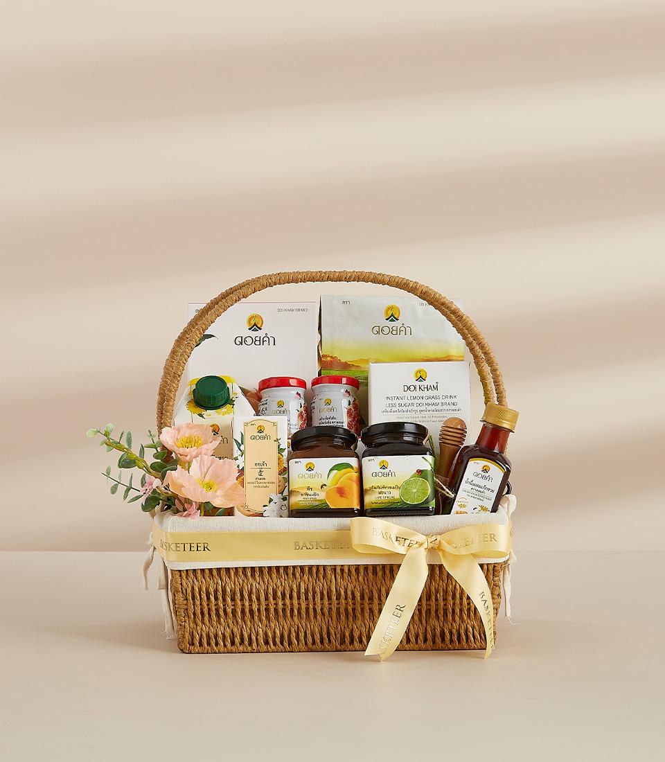 Woven brown gift basket with yellow Basketeer ribbon, filled with Thai heritage gourmet products including preserves,