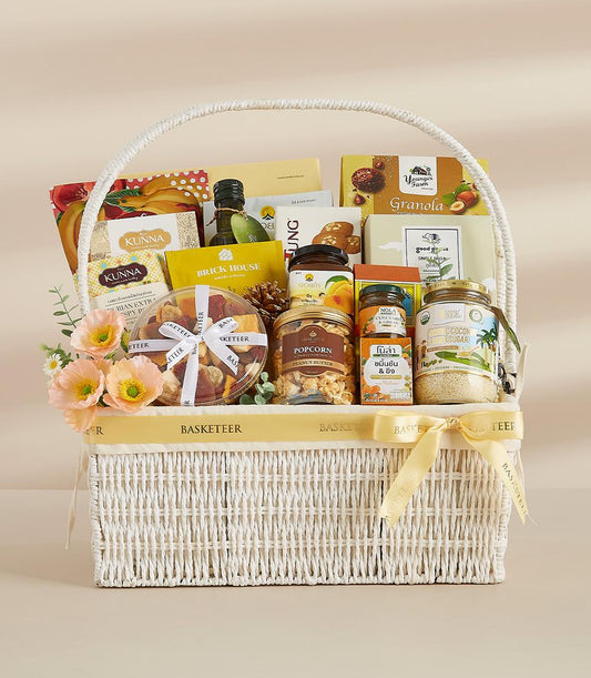Taste of Thailand white wicker gift basket with gourmet snacks, granola, and peach flowers for New Year gifting