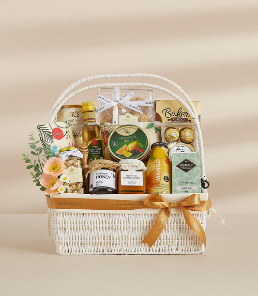 Luxury white wicker gourmet gift basket with honey, tea, marmalade, and artisan treats for New Year