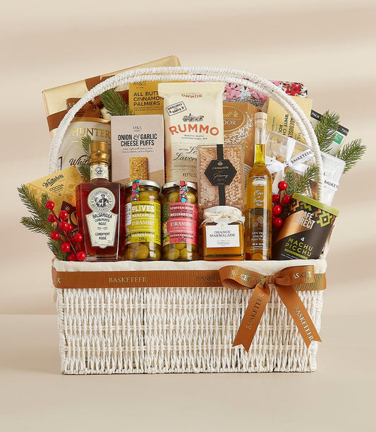 Basketeer premium hamper: A generous gift of gourmet olives, balsamic glaze, and pasta in a white wicker basket with a brown Basketeer ribbon.