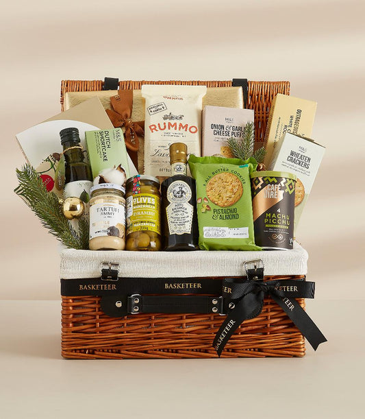 Two-tiered wicker hamper with gourmet olive oil, truffle spread, olives, balsamic glaze, cookies, coffee, pasta, and crackers