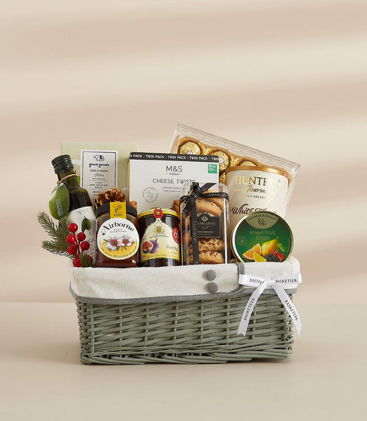 Luxe grey wicker New Year gift basket with olive oil, honey, jam, gourmet chocolates, and artisan treats