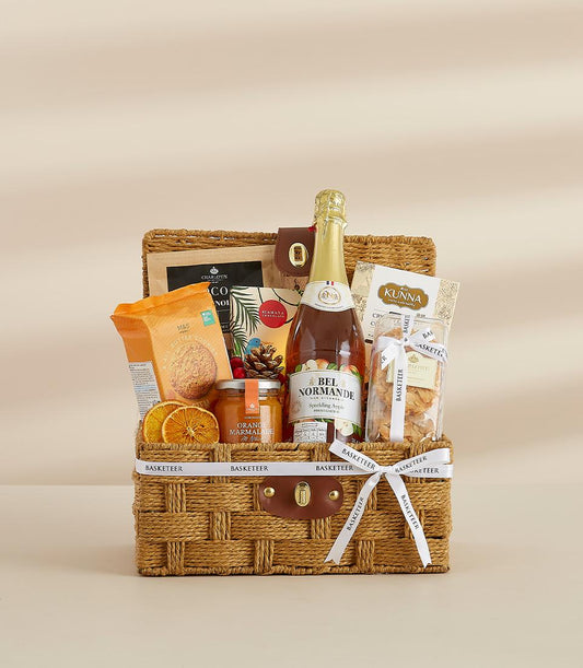 Woven luxury gift basket with sparkling cider, gourmet cookies, and artisan treats for New Year celebrations