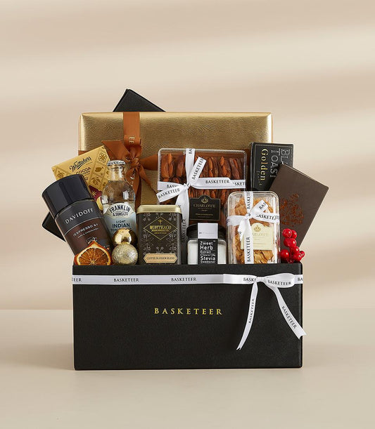 Luxury gourmet gift basket with premium coffee, tonic, dried fruits, and artisan treats in black presentation box with gold
