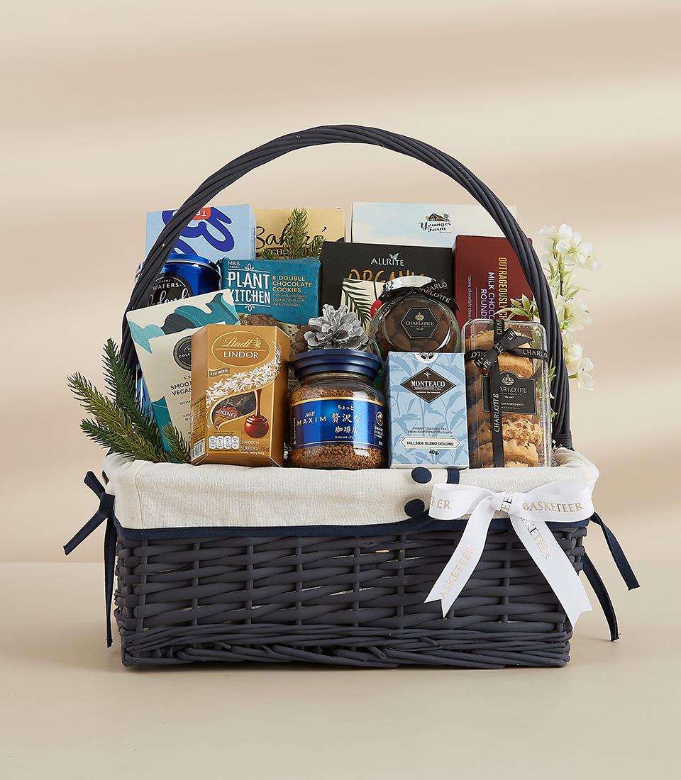Premium grey woven gift basket with gourmet chocolates, coffee, tea, and artisan snacks for New Year celebrations