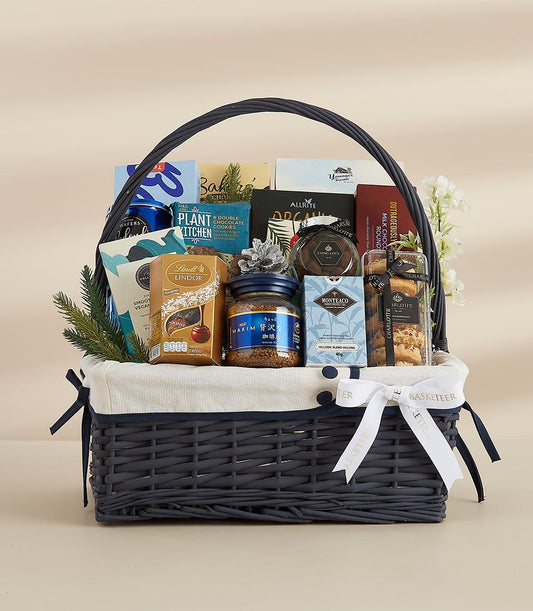 Premium grey woven gift basket with gourmet chocolates, coffee, tea, and artisan snacks for New Year celebrations