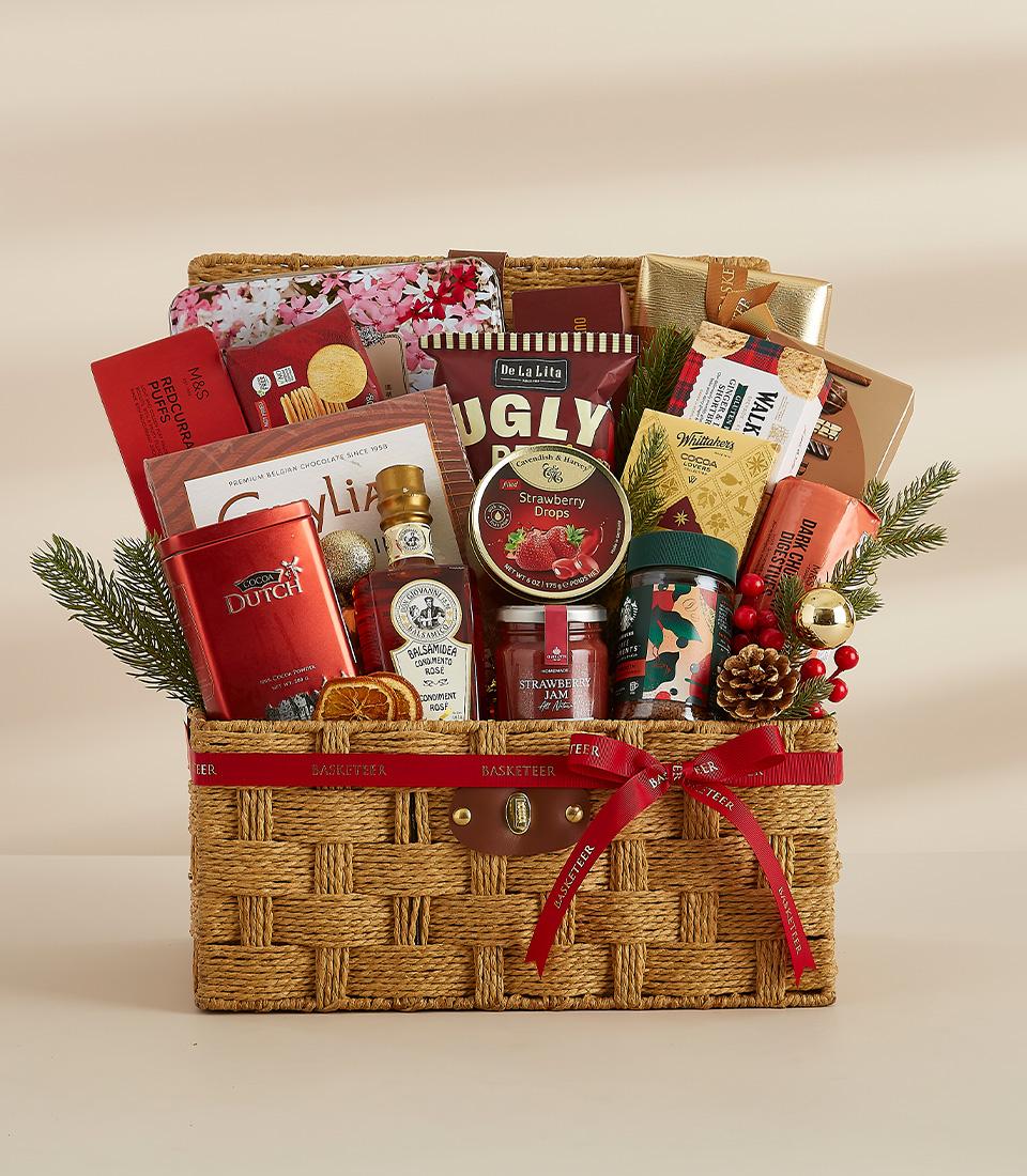 Woven luxury gift basket with gourmet treats, festive greenery, and gold accents