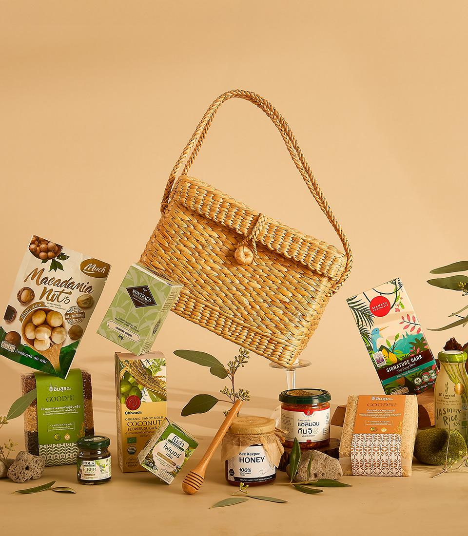 Healthy Harvest curated gift hamper with organic nuts, tea, honey, chocolate and grains in woven straw basket