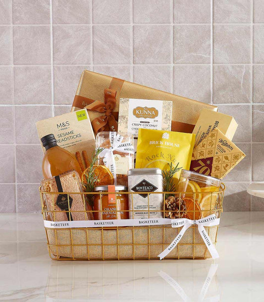 Gold wire gift basket filled with gourmet treats, chocolates, and artisan snacks for New Year celebrations