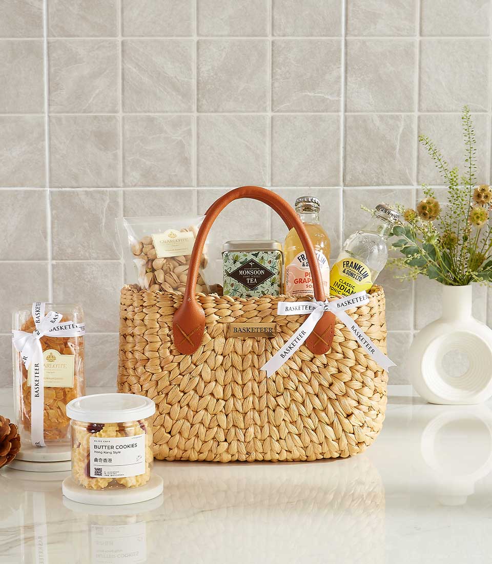 Woven straw gift basket with pistachios, gourmet tea, artisan sodas, and premium treats for New Year gifting