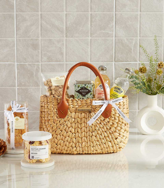 Woven straw gift basket with pistachios, gourmet tea, artisan sodas, and premium treats for New Year gifting