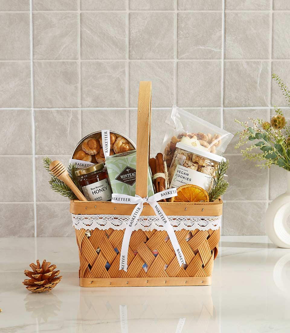 Woven gift basket with honey jar, vegan cookies, nuts, and wellness treats for New Year gifting