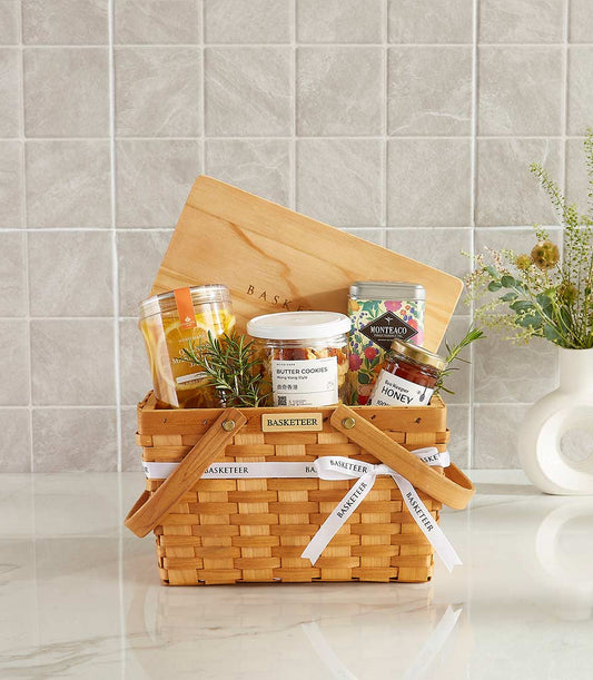 Woven gift basket with gourmet goodies, honey, butter cookies, and fresh rosemary for New Year celebrations