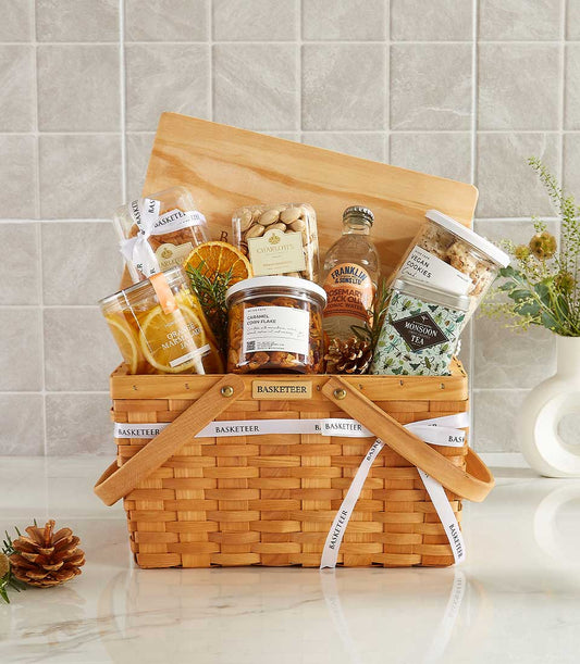 Woven wooden gift basket with marmalade jam, gourmet snacks, artisan tea, and tonic water for New Year wellness gifting
