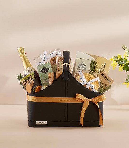 Luxury black gift basket with champagne, gourmet crackers, and artisan treats tied with gold ribbon