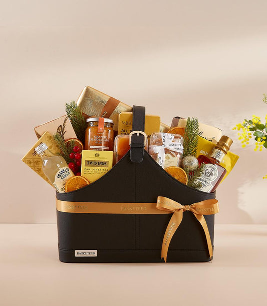 Luxury New Year gift basket with gourmet tea, marmalade, and gourmet essentials in black leather container with golden ribbon