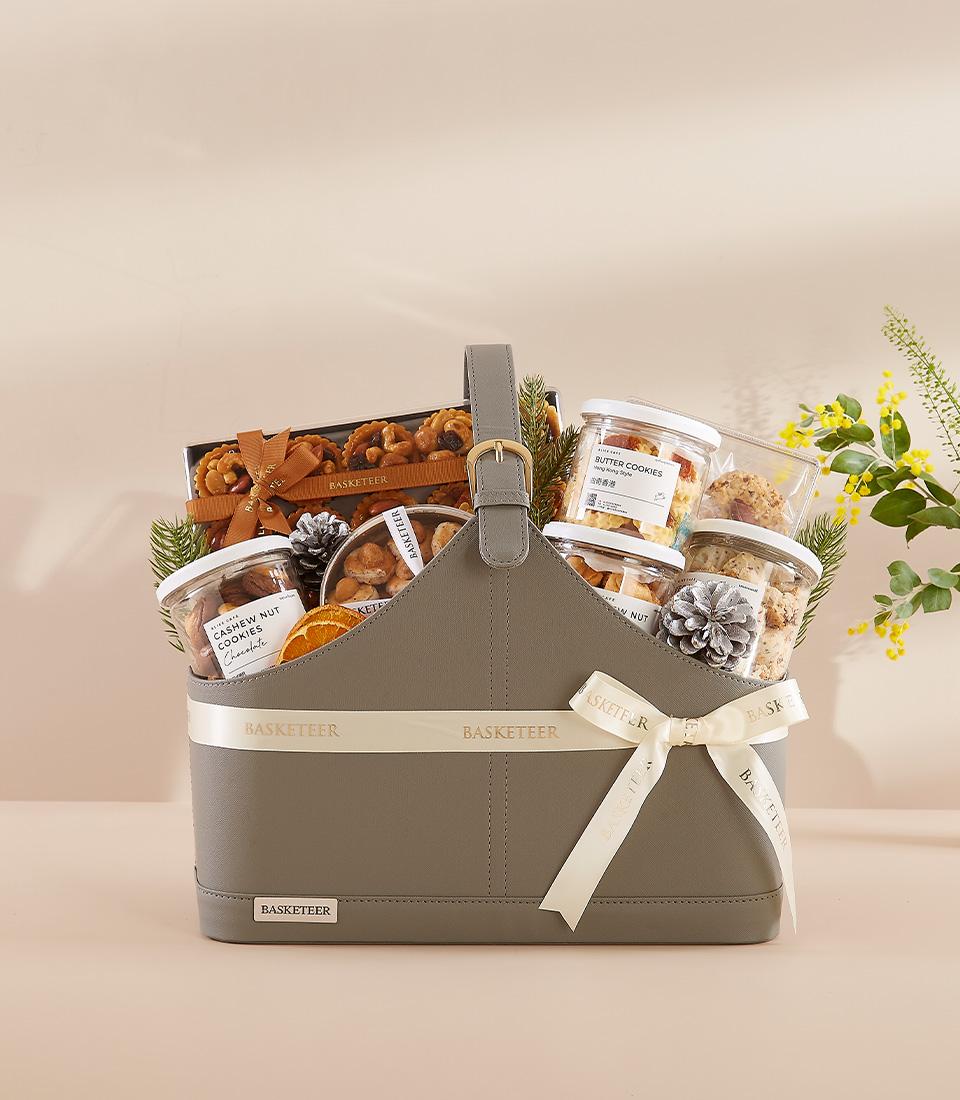 Grey faux leather gift basket with gourmet cookies, cashew nuts, and artisan treats tied with cream ribbon