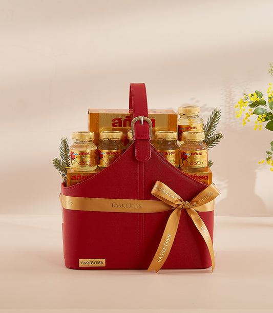Luxurious red leather wellness basket with golden bottled supplements, Thai script box, and gold ribbon for New Year gifting