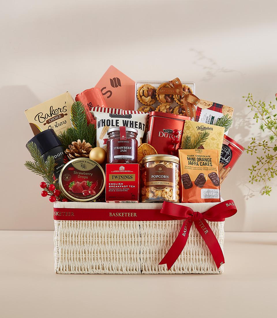 Premium New Year gift hamper with gourmet treats, tea, jam, and chocolate in white woven basket with red ribbon