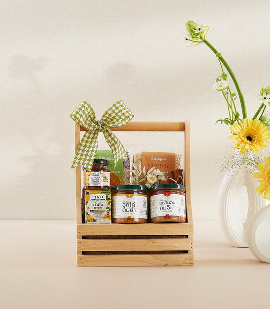 Premium Thai gourmet gift set in wooden basket with manuka honey, artisan spreads, and fresh yellow gerbera daisies