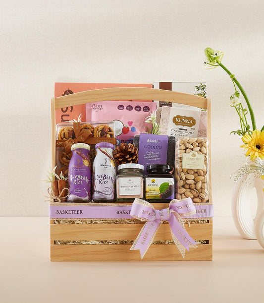 Wooden wellness gift basket with riceberry drinks, coconut waffle treats, pistachios, and Himalayan salt for New Year