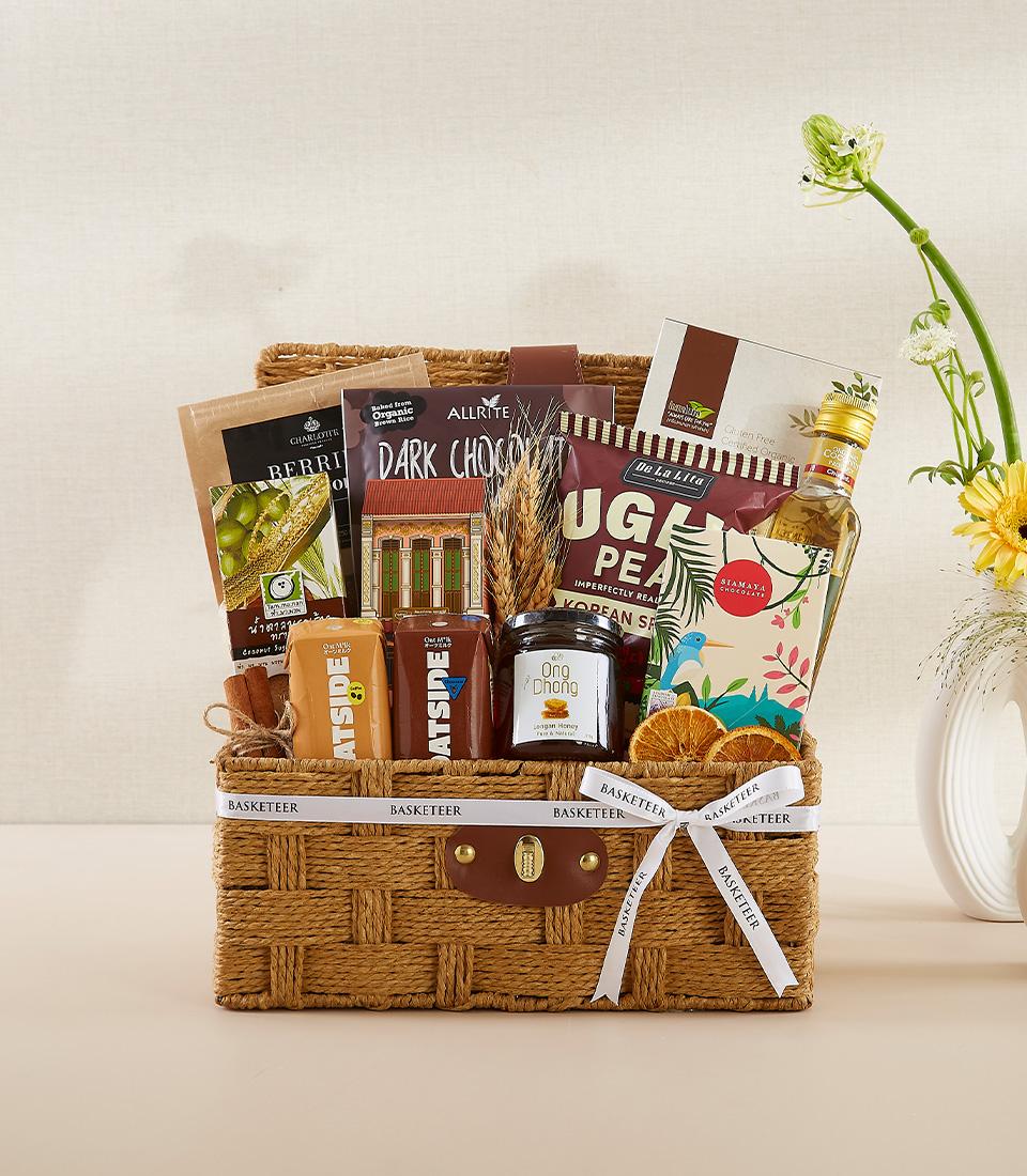 Woven gift basket with dark chocolate, UGA pea snacks, longan honey, and beverage for New Year wellness gifting